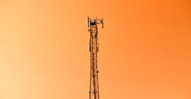 Radio mast silhouetted against a vibrant orange sky in Adana, Türkiye.