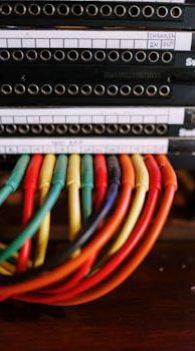 Vibrant cable wires connected to a patch panel in a professional audio setup.